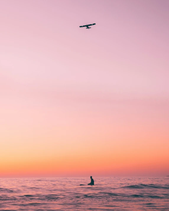 a airplane flying above the water and a man in a canoe