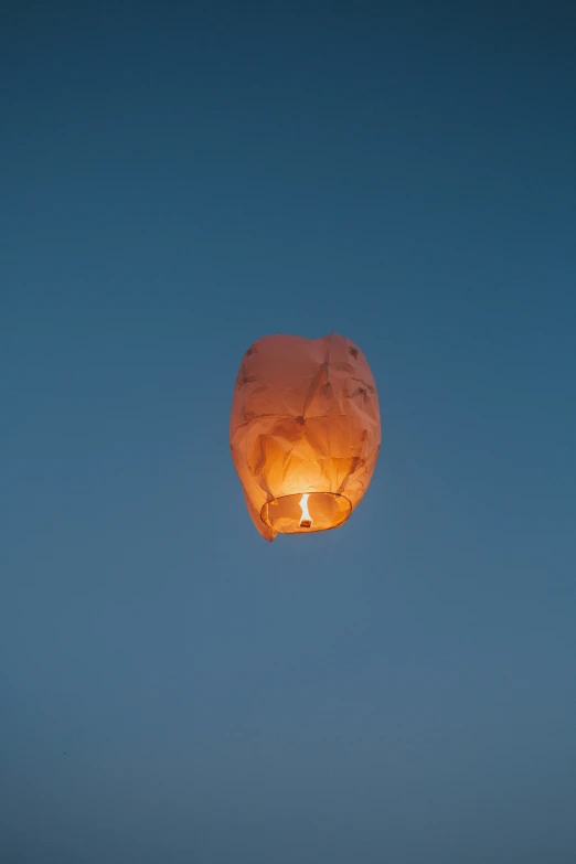 a glowing balloon flying through the blue sky