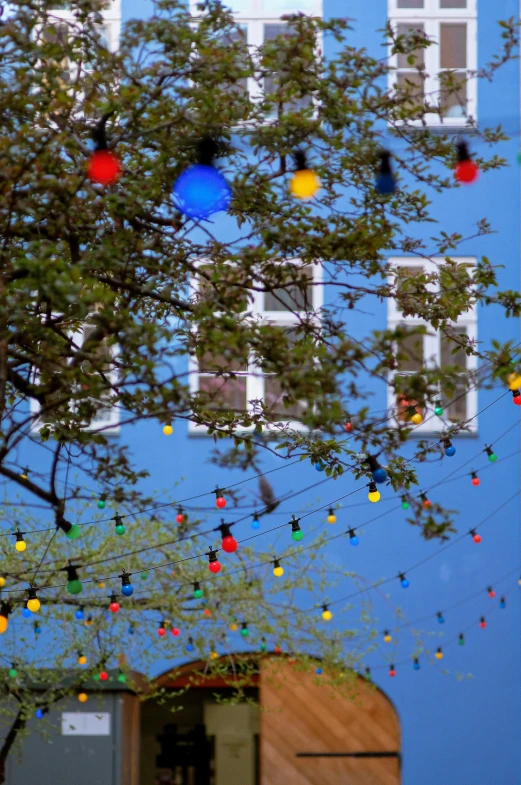 many colorful ornaments hang above a city street