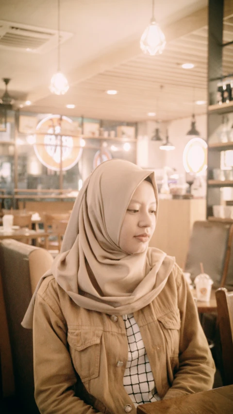 the woman sits alone in the restaurant while the lights are on