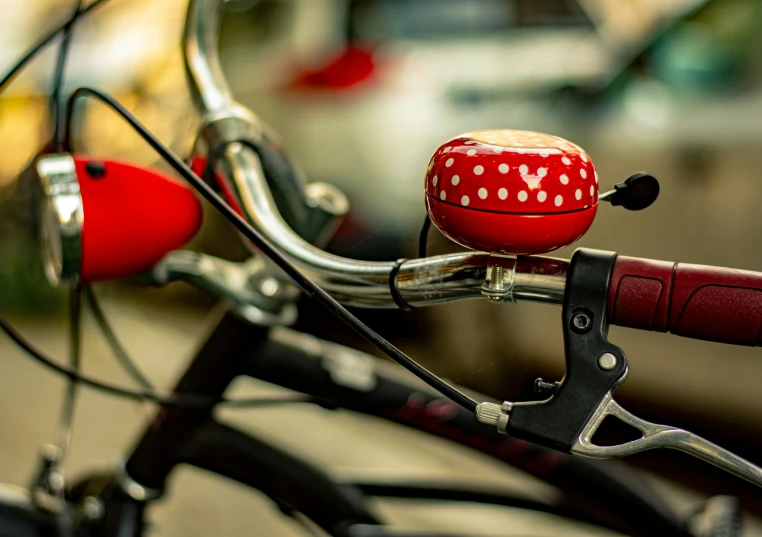 a close up po of a bike handle bar and red polka dot bike stem