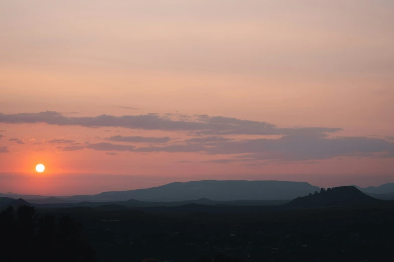 the sun is setting behind some mountains