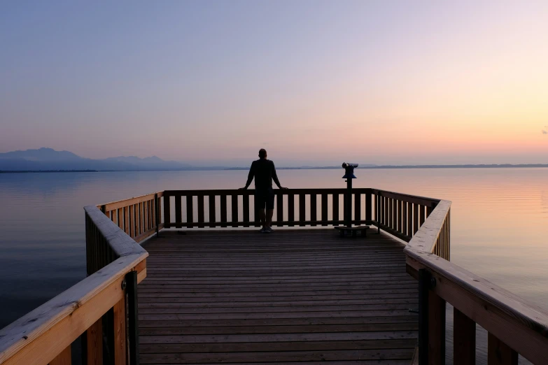 a person standing on a dock overlooking the water