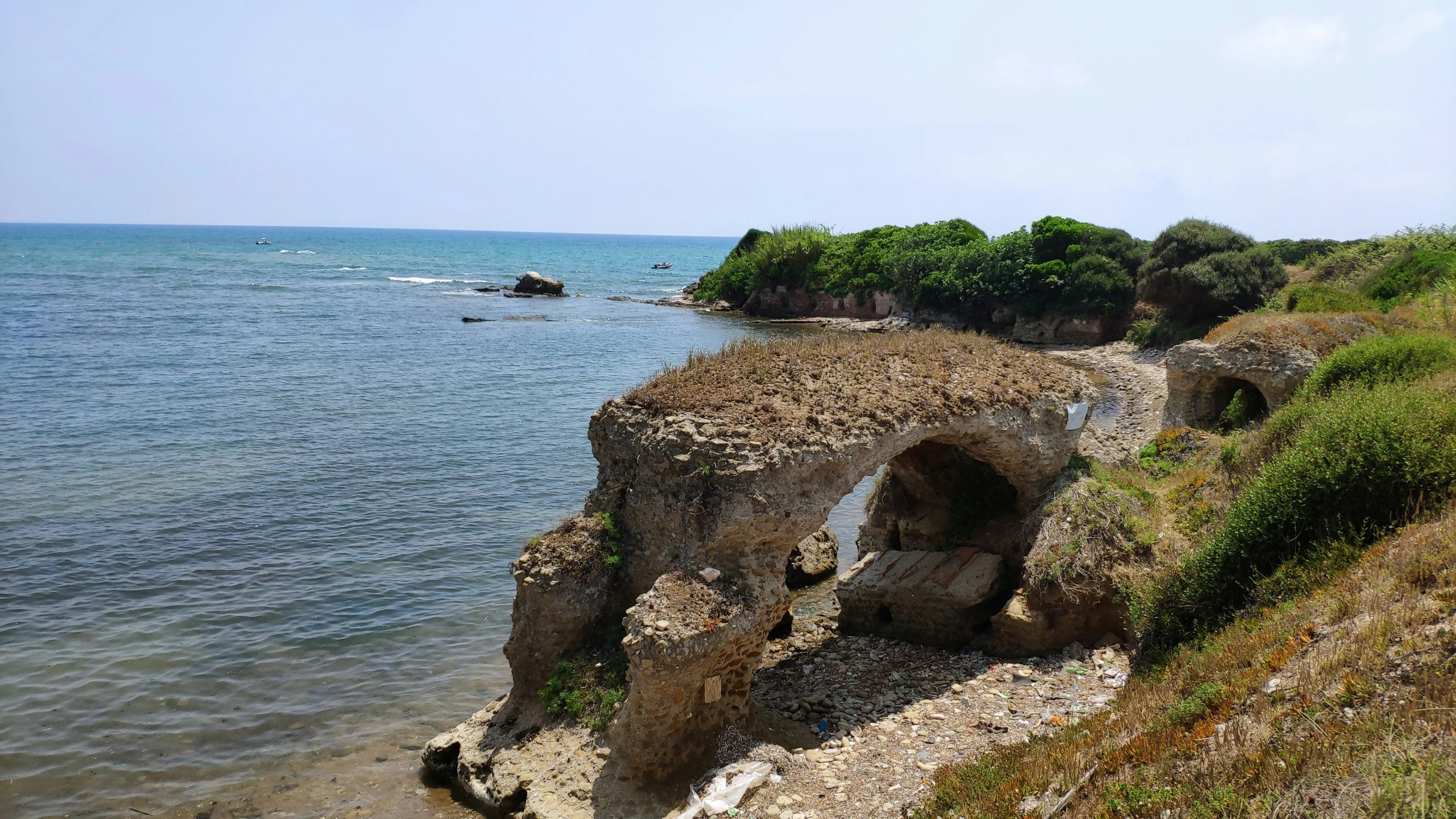 an ocean side tunnel leads to an island in the background