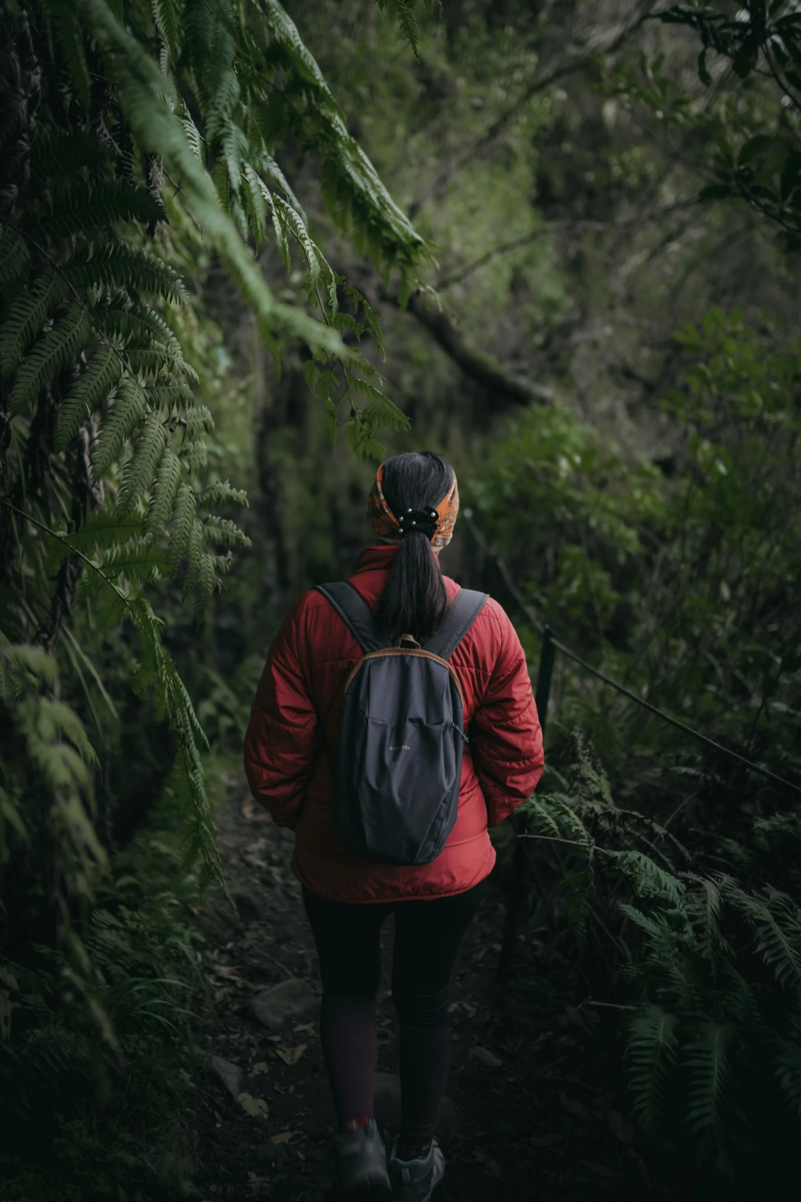 the woman is walking alone through the woods