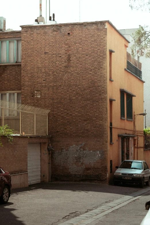 a small car parked in front of a brown brick building