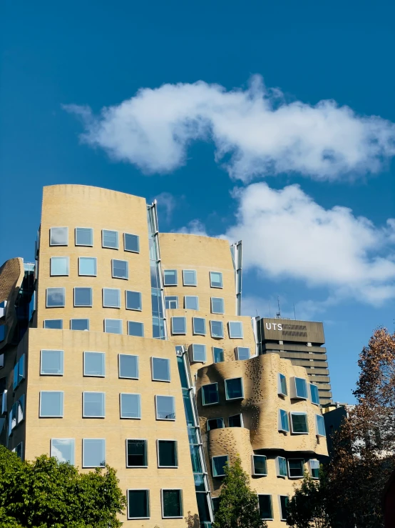 a tall yellow building with many windows under a blue sky