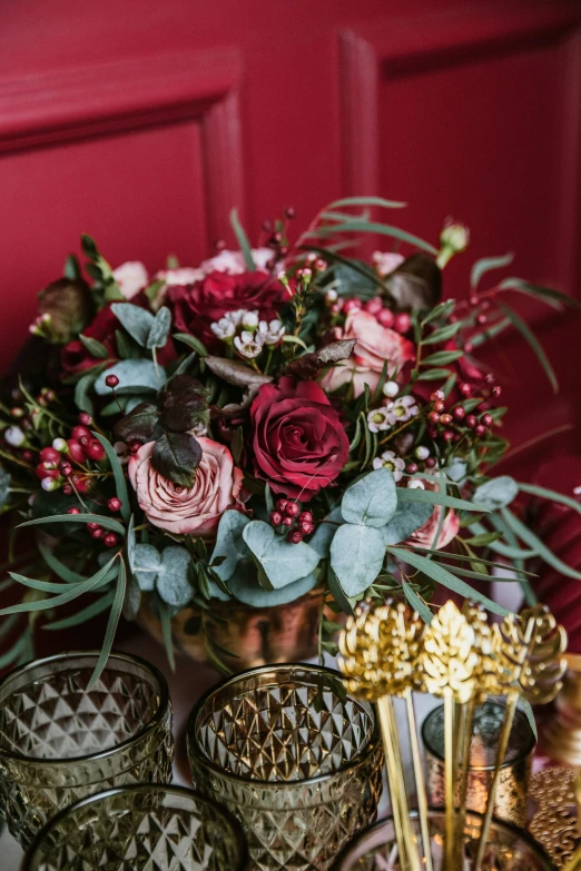 a table with several glasses and a vase with flowers