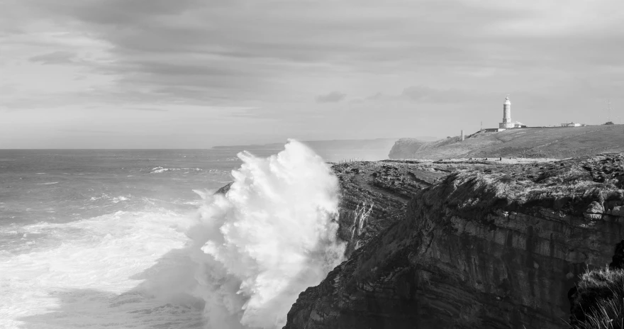 waves crash over cliffs as lighthouses look on