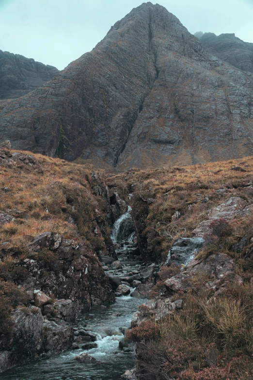 an image of mountain scenery with a stream running between the rocky hills