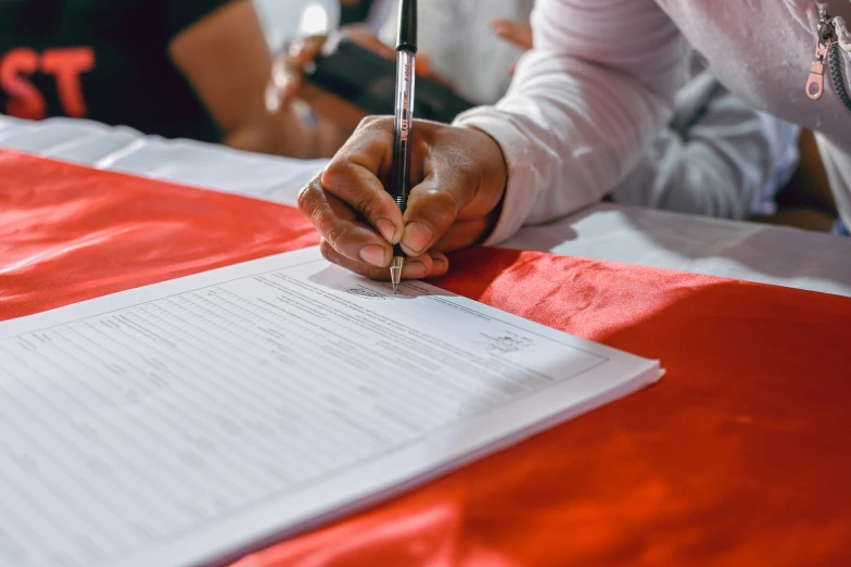 hands signing on paper and pen, in preparation for meeting