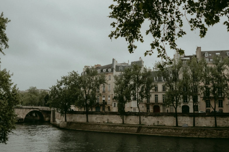 a large river flowing past a building near a bridge