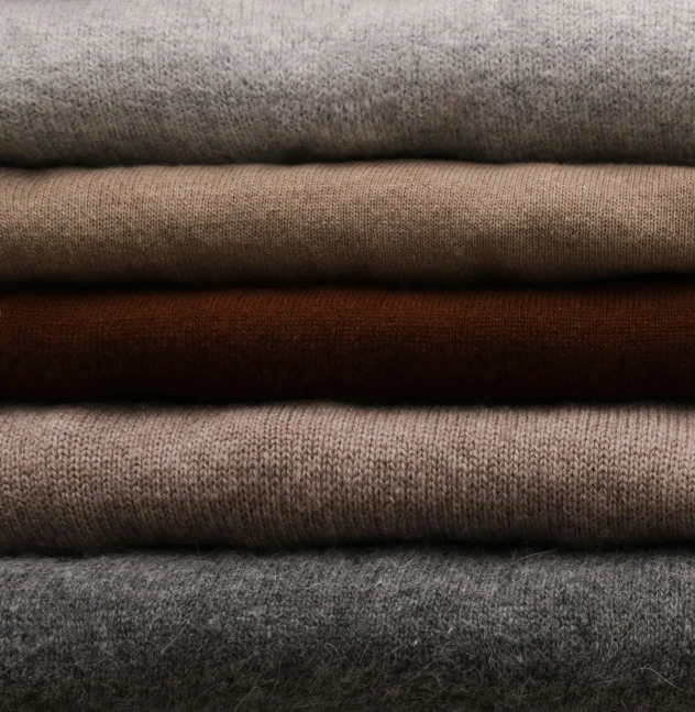 several different color and textured fabrics are stacked next to each other