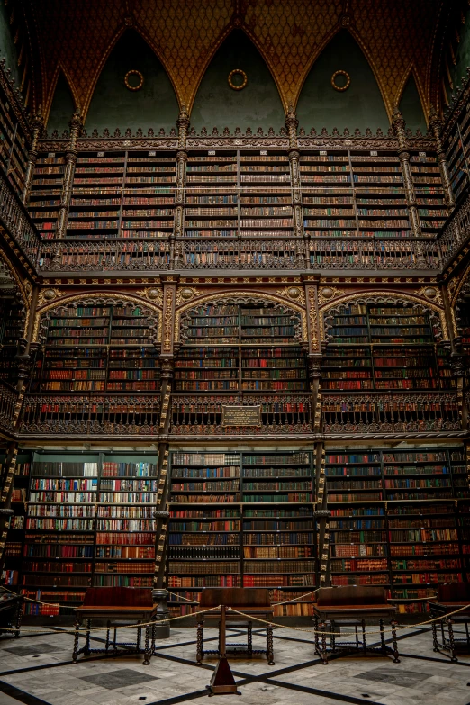 several benches that are sitting next to a large book shelf