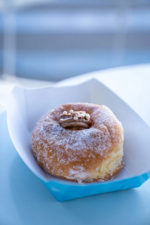 a doughnut with some nuts sitting on top of a table