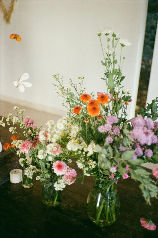 a variety of flowers in glass vases on a table