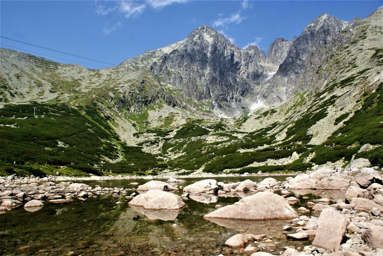 a small river runs between rocky mountain peaks