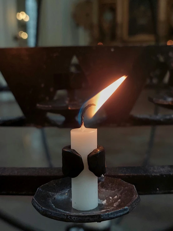 a candle with one candle lit on a small plate