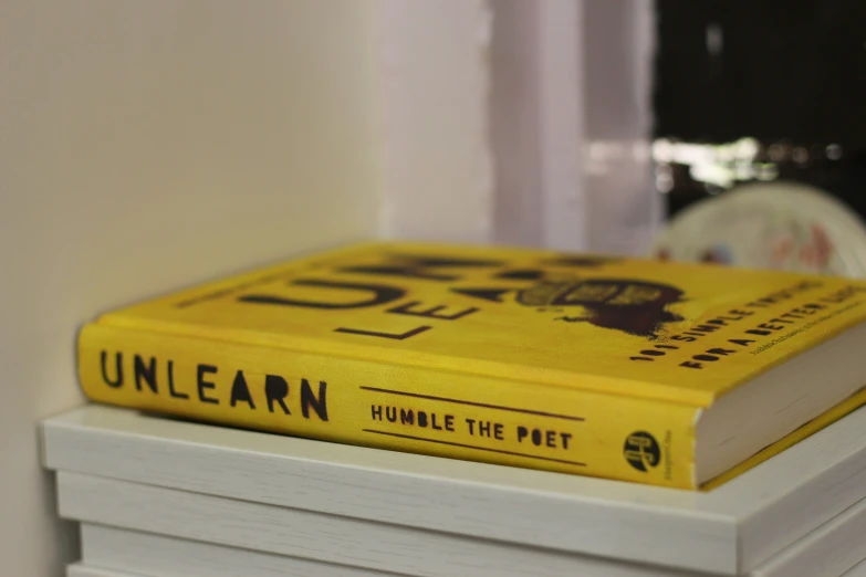 a close up of a yellow book on a stack