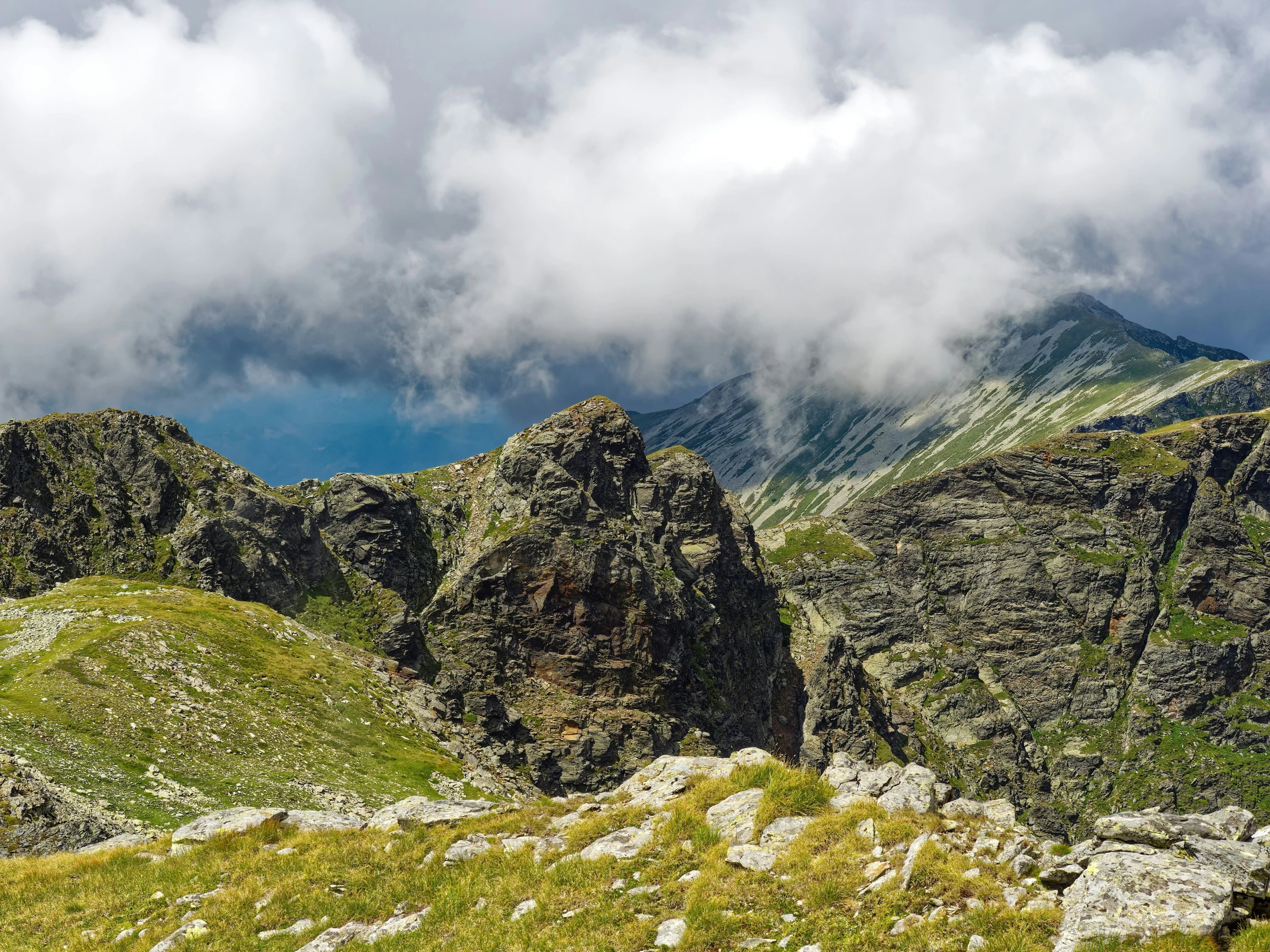 the view looking down at a green mountain ridge