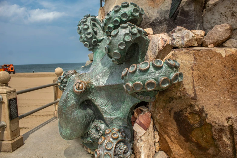 a statue that looks like an octo on the beach