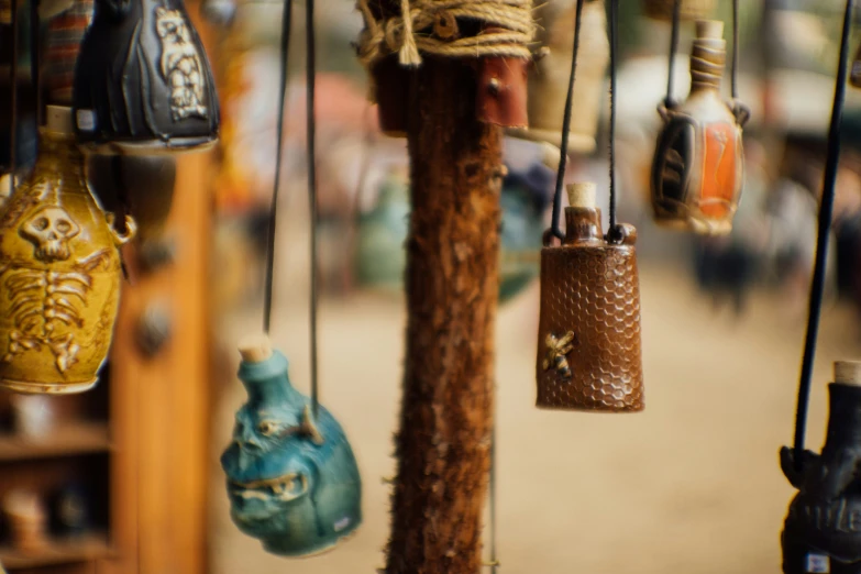 a wooden pole holding a bunch of assorted hand made pots