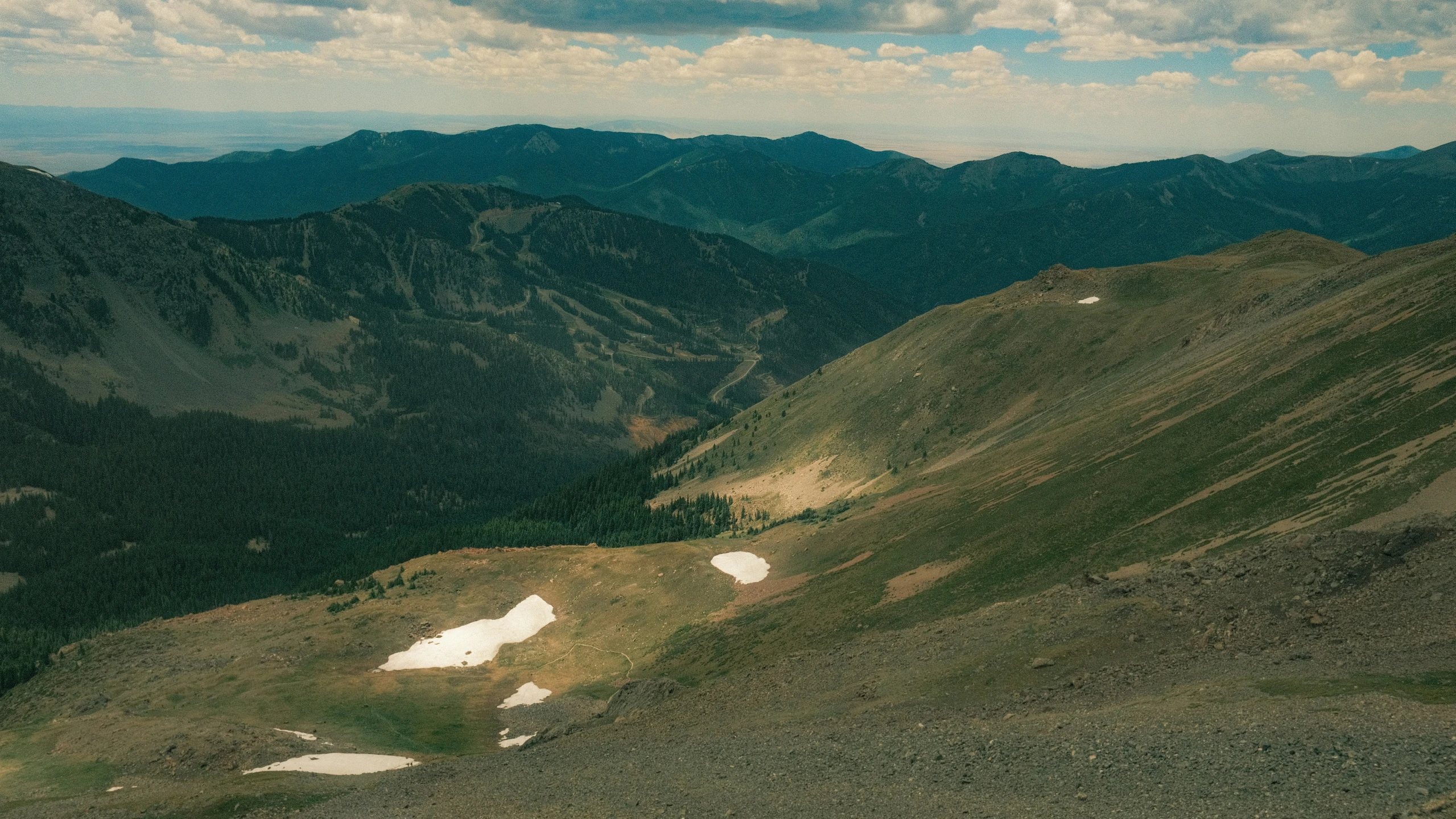 some mountains with snow and rocks on one side