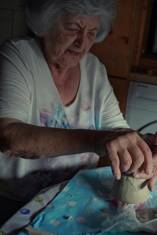 an older woman using a small rolling pin