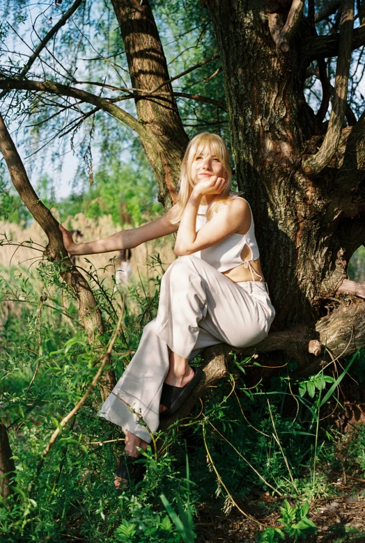 a girl is sitting in a tree looking ahead