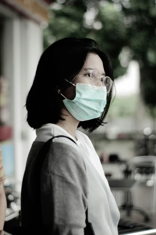 a woman wearing a face mask while staring at soing