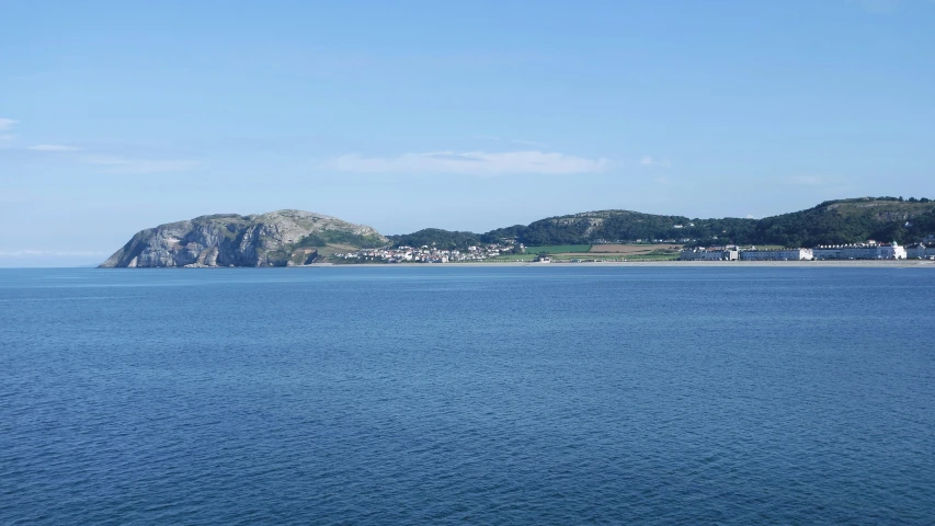 a boat traveling on the ocean near a large island