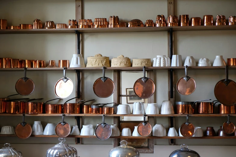 a kitchen is filled with assorted copper pans