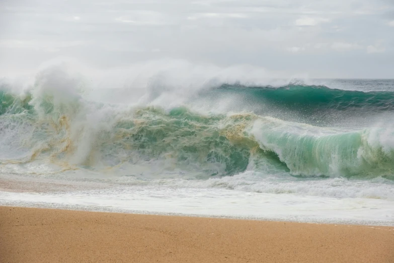 a beach with waves crashing and foaming on the sand