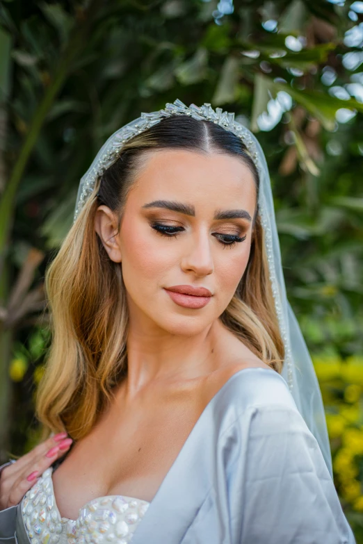 a woman in wedding clothes holding on to her veil