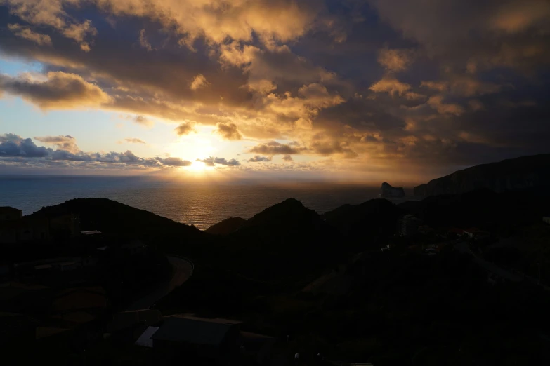 the sun is shining through clouds over the ocean