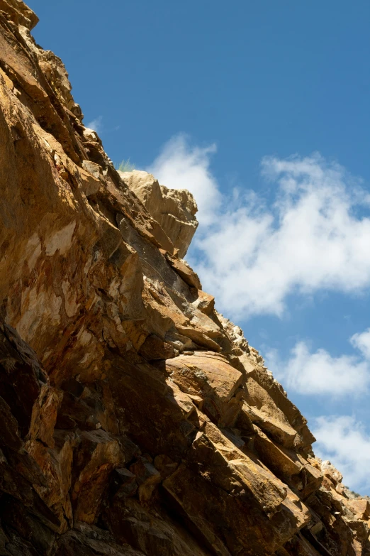 a bird is sitting on the rocks under a blue sky