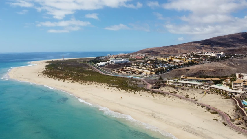 a beach with a sandy shore under a blue sky