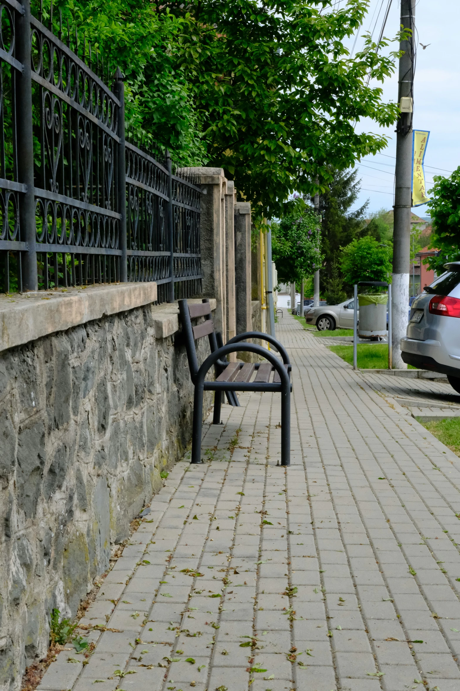 a lone park bench at a stone wall in the city