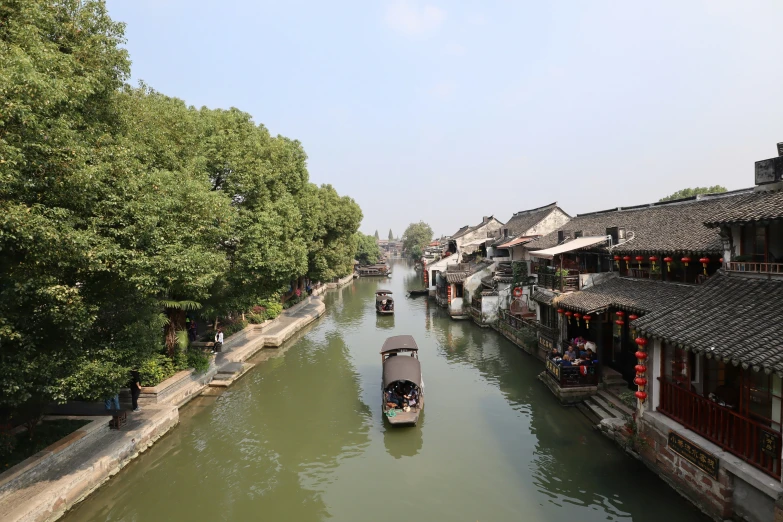 an overview of a canal with many boats passing on one side