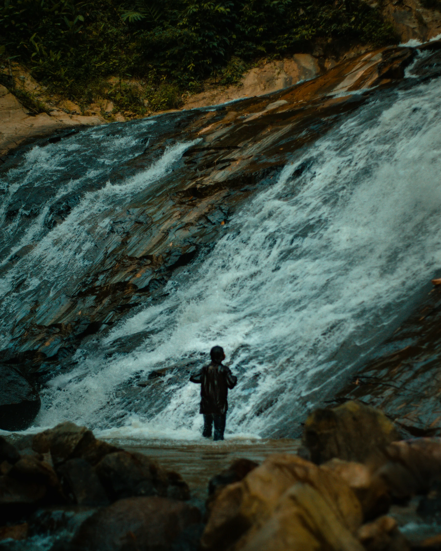 a person standing in front of a waterfall