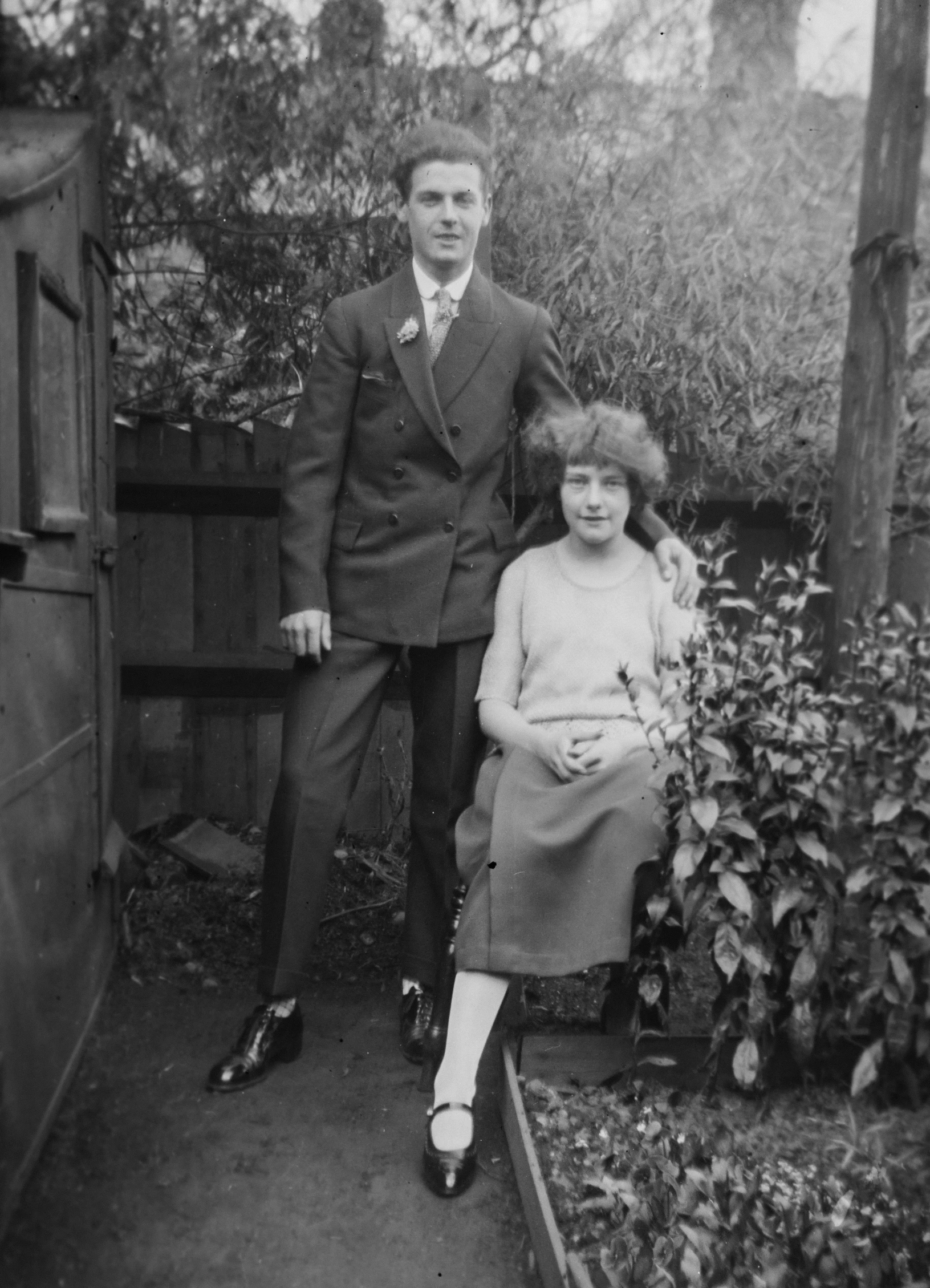 an old black and white pograph of a couple standing outside