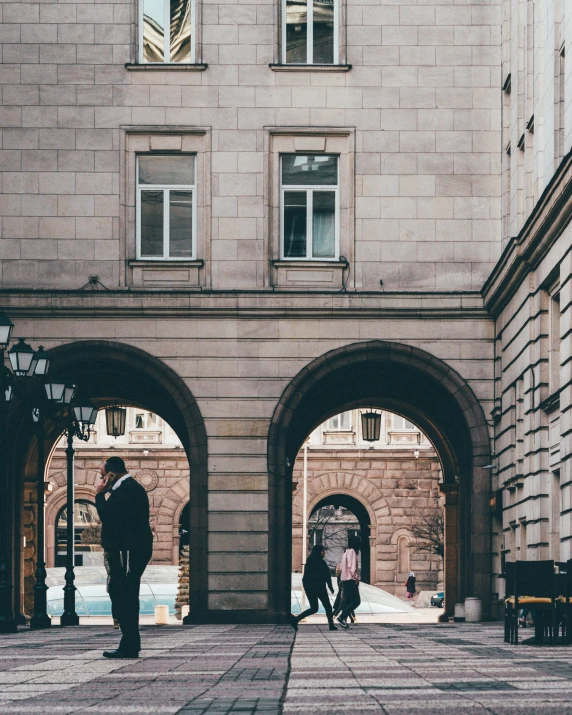 the couple is standing in the middle of an arch near two people