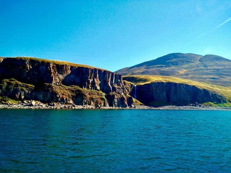 the mountain and its steep cliff near a body of water