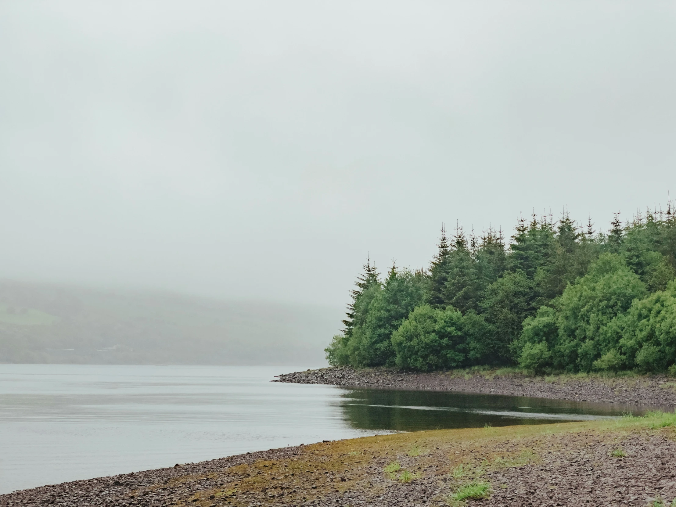 a man walking along the shore of a lake