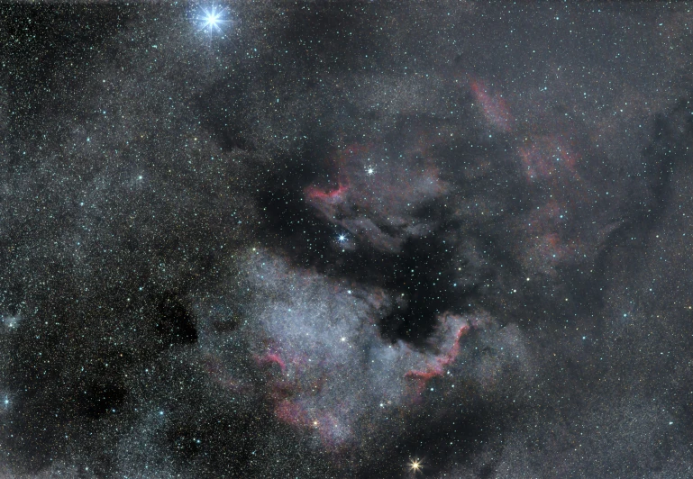 a cloud formation in the dark sky with stars and small objects in it