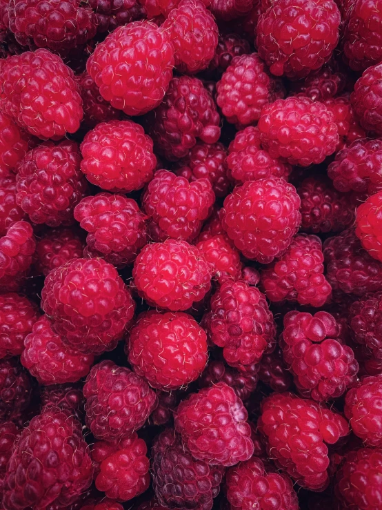 a lot of raspberries piled on top of each other