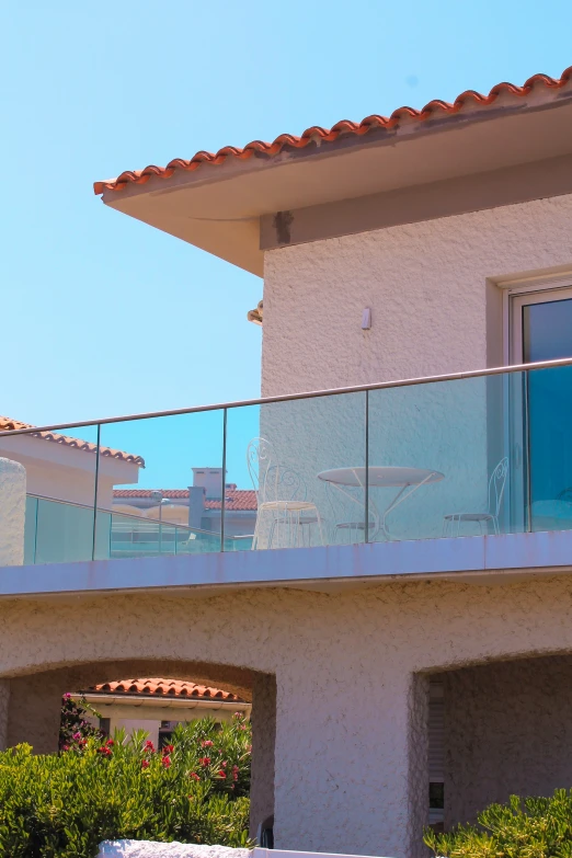 a balcony over looking the beach with chairs and flowers