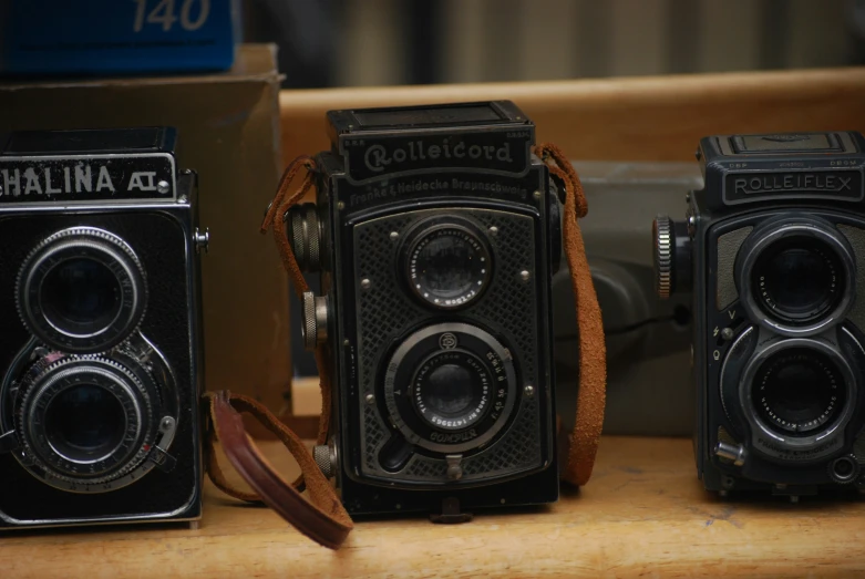 three old fashioned camera sitting side by side