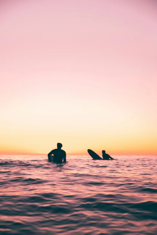 two men on surfboards in a large body of water