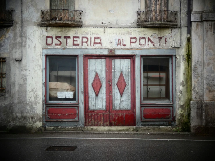 an old building that is red and white with the doors painted white